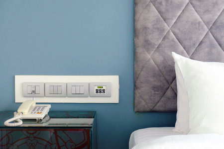Luxury headboard with set of accessories, bed, pillows, bed sheet, table, telephone, switches, and...