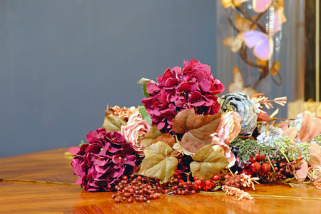 Beautiful decorative vintage flowers on shiny wood surface table with copy space