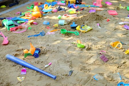 Children toys spreading on sand pile in playgroundの写真素材