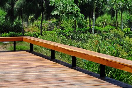 Plain wood outdoor balcony to the fresh green garden