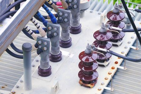 Closeup electrical insulators with the wiring cable and connectors on a transformer