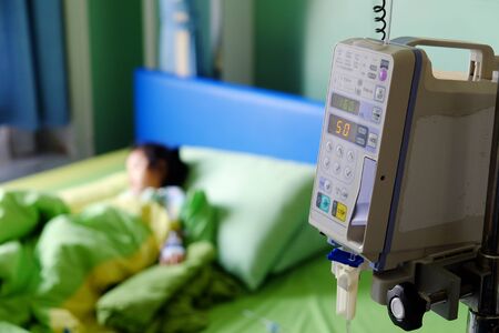 Vital sign monitor with background of blurry baby patient on bed in hospital