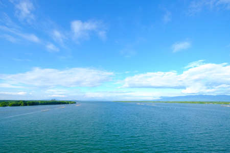 Beautiful landscape estuary of a river where the water meets the cloudy blue sky