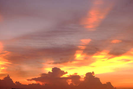 Dramatic dusk sky during sunset with sunlight ray through the cloudsの写真素材