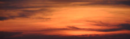 Beautiful sunset sky with orange clouds. Panoramic image.の写真素材