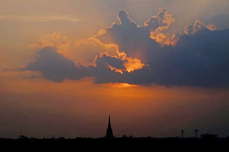 Silhouette Buddhism pagoda on dramatic cloudy sky background during sunsetの写真素材