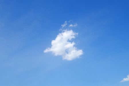 White little cloud, like small dragon opening mouth, on blue sky backgroundの写真素材