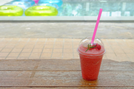 Fresh red watermelon juice on table, outdoors and near the swimming poolの写真素材