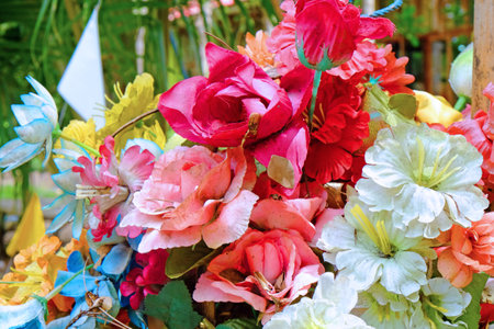 Colorful artificial bouquet of flowers with background of green gardenの写真素材