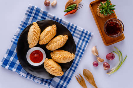 Curry puff or Pastel goreng. it is a small pie consisting of curry with chicken and potatoes in a deep-fried or baked pastry shell. The curry is quite thick to prevent it from oozing out of the snackの写真素材