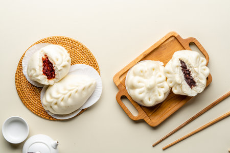 Delicious Baozi, Chinese steamed meat bun is ready to eat on serving plate and steamer. Baozi or Bakpao is a type of yeast-leavened filled bun in various Chinese cuisines.の写真素材