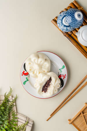 Delicious Baozi, Chinese steamed meat bun is ready to eat on serving plate and steamer. Baozi or Bakpao is a type of yeast-leavened filled bun in various Chinese cuisines.の写真素材