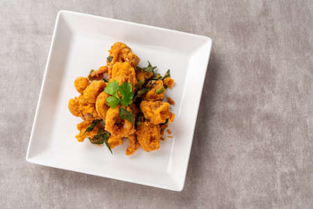 Stir Fried Squid with Salted Egg Yolk plating on white plate.の写真素材