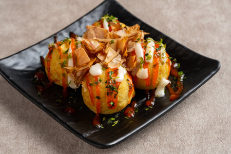 Takoyaki is a ball-shaped Japanese snack made of a wheat flour-based batter and cooked in a special molded panの写真素材