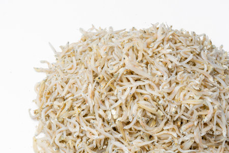 Fresh dried anchovies on White Background. Raw dry salted sea fish. saltwaterforage fish. Ikan asin teri medan.の写真素材