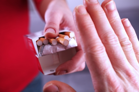 Closeup view showing a person refusing a cigarette and making a hand sign の写真素材