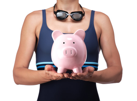 photography of a swimmer holding a piggy bankの写真素材