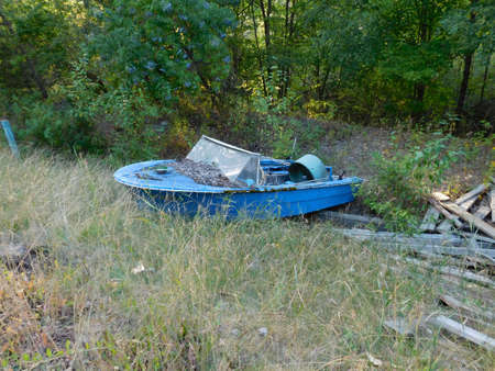 An abandoned blue boat rests in a valley that once held water. Forever forgotten by those who adventured within it.の写真素材