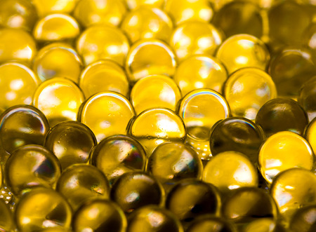 Gold shiny water gel balls. Macro photo, can be used both for advertising or cosmetics, jewellery and for medicine. Abstract background.の写真素材