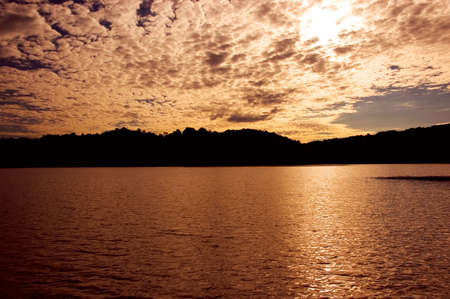Beautiful sunset with clouds over a calm lake.の写真素材