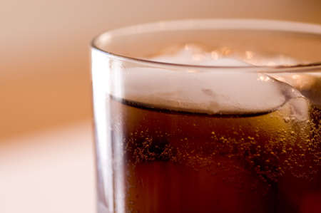 A close-up of a glass of cola on ice.