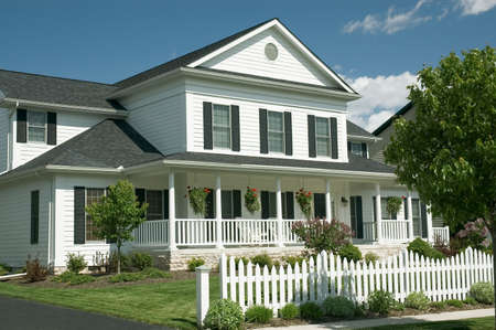 New home with an old country feel. Large front porch and the white picket fence for the old time retro look. Just one of many new house photos in my gallery.の写真素材