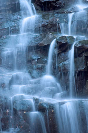 Isolation of part of a waterfall taken with a slow shutter speed to smooth the water, given a cool blue tint for effect. Makes a nice background image.の写真素材