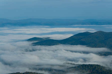 An early morning view across the Appalachian mountain tops along the Skyline Drive in Virginia.  The mountains seem to be poking through the clouds and look almost like islands in a sea. Early morning fog settling into the valleys is very common.の写真素材