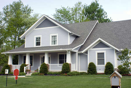 Beautiful new country style wood home featuring a large front porch and nice landscaping.の写真素材