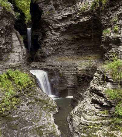 A waterfall at Watkins  Glen state park in New York. Lush green moss and ferns along the steep gorge...