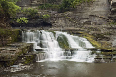 A  beautiful 20 foot waterfall in Enfield Glen which is in Robert Treman state park, New York. Green moss, lichens and ferns along the gorge walls add to the beauty of the scene.の写真素材