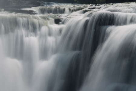 A close-up of a powerful waterfall showing the smooth veil lines of the flowing and tumbling water. Given a slight blue tint for a fresh ,clean, pure look. Lts of interesting details in the photo at full size. の写真素材