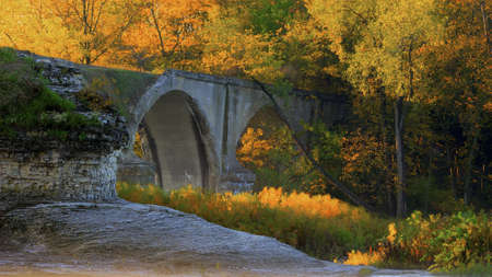 Beautiful autumn sunrise at the Interurban bridge in Toledo Ohio  The bridge is abandoned and now has trees and vegetation growing out of it  の写真素材