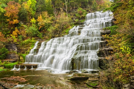 Hector falls  in New York surrounded by trees and plants with peak fall colors  A beautiful roadside waterfall just north of Watkins Glen の写真素材