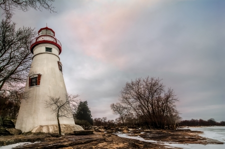 The historic Marblehead Lighthouse in Northwest Ohio sits along the rocky shores of Lake Erie  Seen here in winter with snow on the ground の写真素材