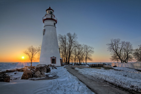 The historic Marblehead Lighthouse in Northwest Ohio sits along the rocky shores of Lake Erie  Seen here at in winter sunrise  の写真素材