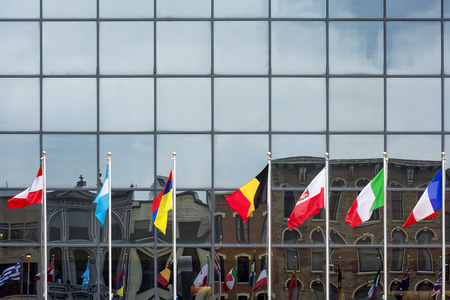 International flags in front of a glass building.