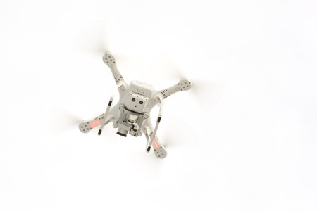 Photo of a flying camera drone isolated against a white background.の写真素材