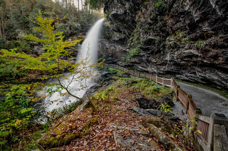 Dry Falls is a scenic 65 foot waterfall close to Highlands North Carolina. As you can see from the photo you can walk behind the waterfall. Seen here in autumn.の写真素材