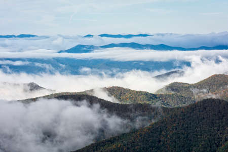 Early morning fog settles into the valleys of the mountains along the Blue Ridge Parkway in Western North Carolina on a crisp autumn October day.の写真素材