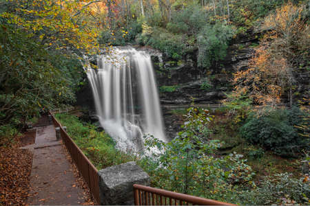 Dry Falls is a scenic 65 foot waterfall close to Highlands North Carolina. As you can see from the photo you can walk behind the waterfall. Seen here in autumn.の写真素材