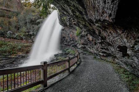 Dry Falls is a scenic 65 foot waterfall close to Highlands North Carolina. As you can see from the photo you can walk behind the waterfall. Seen here in autumn.の写真素材