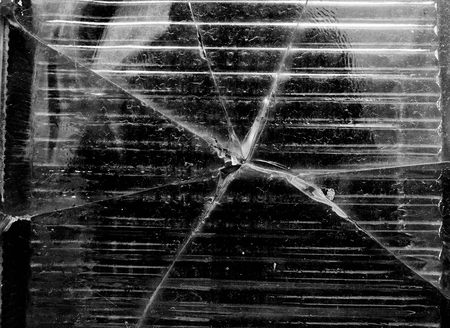 Big crack on the square piece of the glass wall right in the middle of some man refletion black and...
