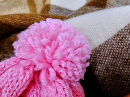 Handmade pink pompon on top of the winter hat close-upの写真素材