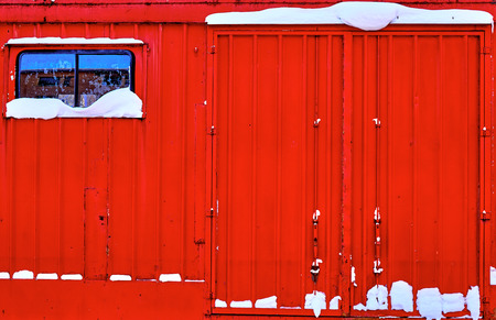 Red industrial wagon covered by snowの写真素材
