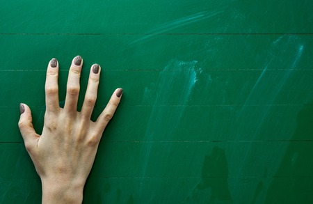 Right palm of a young girl resting on the green school board backgroundの写真素材