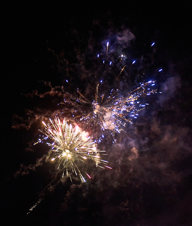 Colorful bright red and blue fireworks and smoke in the night sky close-up vertical background
