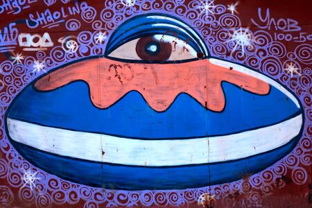 KIROV, RUSSIA - APRIL 15, 2018: Abstract blue and purple graffiti of the UFO on the red wallのeditorial素材