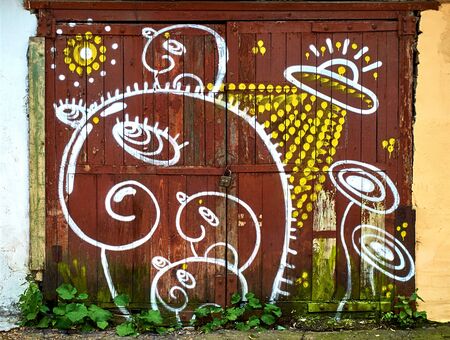 KIROV, RUSSIA - JULY 19, 2017: Abstract white and yellow graffiti of the UFO on the red doorのeditorial素材