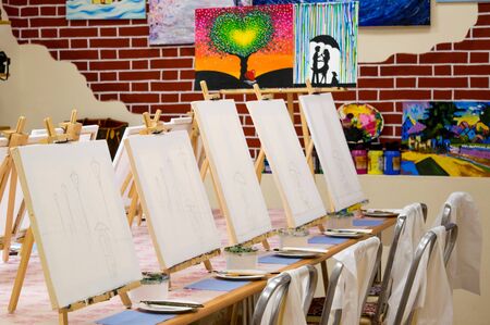 KIROV, RUSSIA - JUNE 23, 2017: Canvases standing in a row on the long table in the local art studio in preparation for the artistic masterclassのeditorial素材